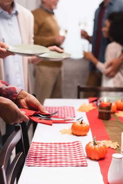 Selective focus of multicultural women serving table during thanksgiving with family — Stock Photo