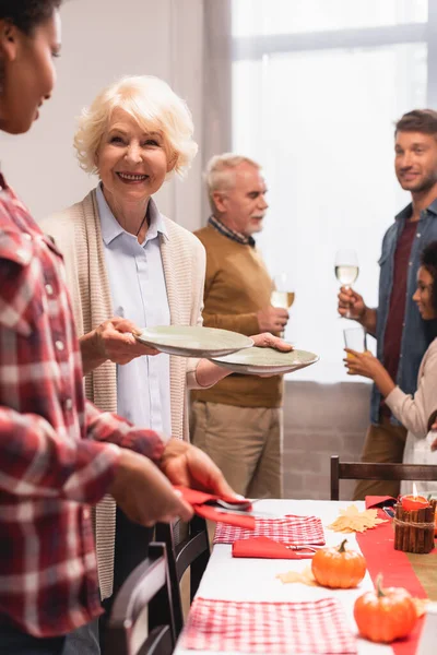 Selective focus of multiethnic family serving table during thanksgiving celebration at home — Stock Photo