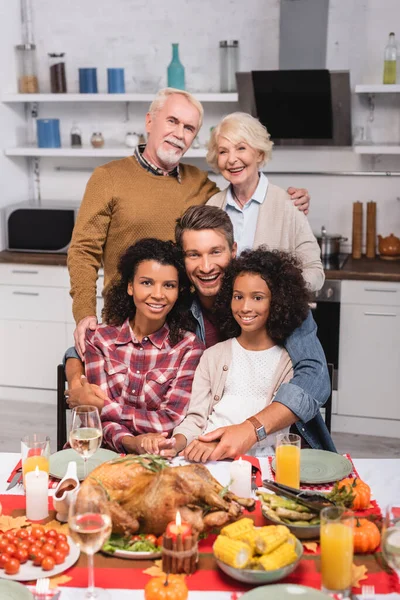 Focus selettivo della famiglia multiculturale che abbraccia durante la celebrazione del Ringraziamento — Stock Photo
