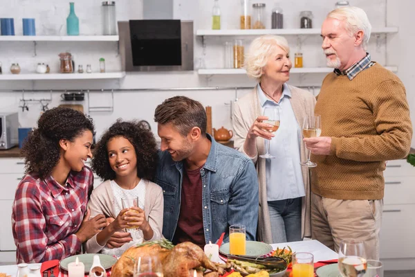 Selektiver Fokus der multikulturellen Familie mit Tochter im Gespräch bei Erntedankfeier — Stockfoto