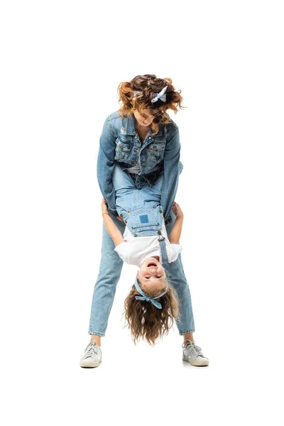 Mother and daughter in denim outfits having fun isolated on white — Stock Photo