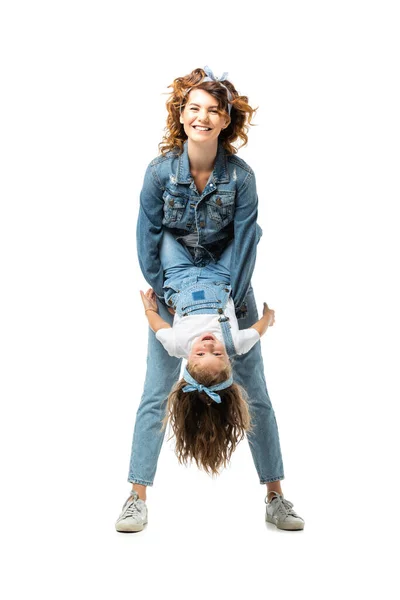 Мать и дочь в джинсовых нарядах веселятся изолированно на белом — стоковое фото