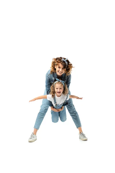 Madre sosteniendo hija imitando plano aislado en blanco - foto de stock