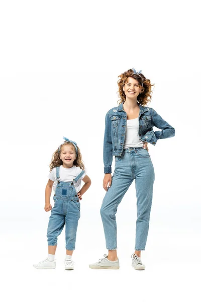 Мать и дочь в джинсовой одежде позируют изолированно на белом — стоковое фото