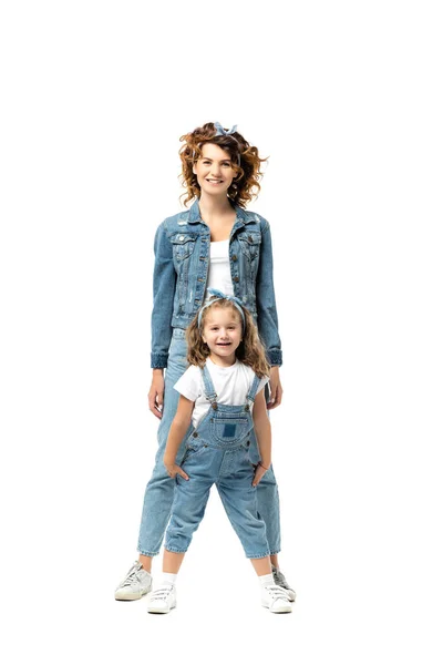 Мати і дочка в джинсових вбраннях позує ізольовано на білому — стокове фото