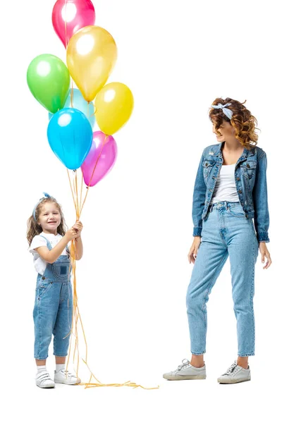 Mãe perto da filha com balões coloridos isolados em branco — Fotografia de Stock