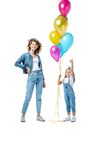 Mother near daughter with colorful balloons showing thumb up isolated on white — Stock Photo