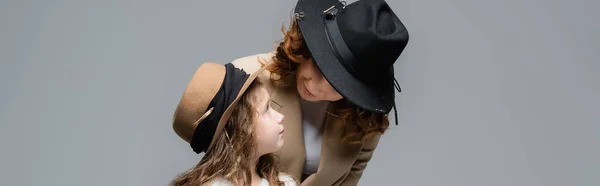 Елегантна мати і дочка в капелюхах ізольовані на сірому, панорамний знімок — стокове фото