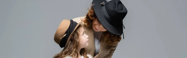 Élégante mère et fille dans des chapeaux isolés sur gris, vue panoramique — Photo de stock