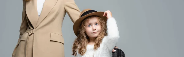 Elegant daughter in hat posing near mother isolated on grey, panoramic shot — Stock Photo