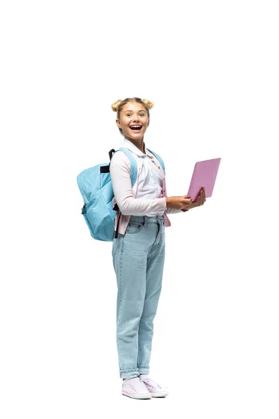 Enfant excité avec sac à dos tenant ordinateur portable sur fond blanc — Photo de stock