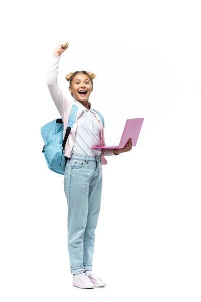 Aufgeregtes Schulkind zeigt Ja-Geste, während es Laptop auf weißem Hintergrund hält — Stockfoto