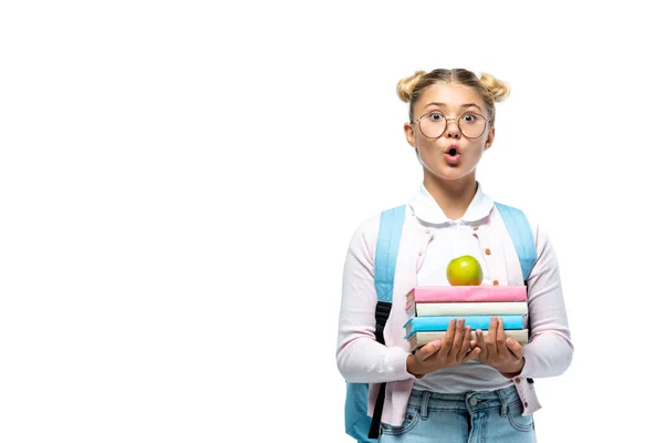 Écolière choquée tenant pomme et livres isolés sur blanc — Photo de stock