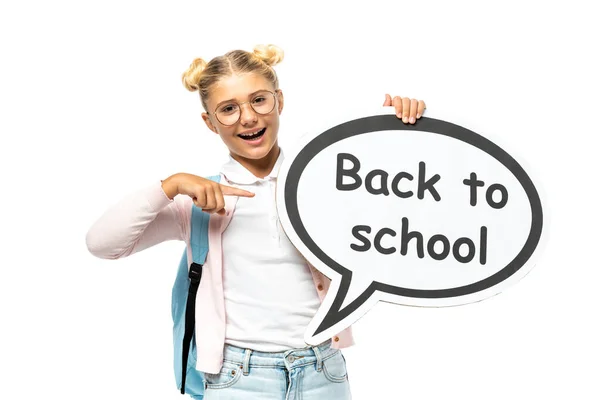 Schoolkid pointing with finger at speech bubble with back to school lettering isolated on white — Stock Photo