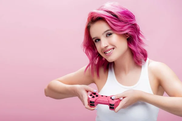KYIV, UKRAINE - JULY 29, 2020: young woman with colorful hair holding joystick isolated on pink — Stock Photo