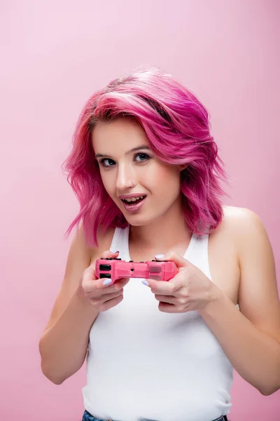 KYIV, UKRAINE - 29 JUILLET 2020 : jeune femme aux cheveux colorés tenant joystick isolé sur rose — Photo de stock