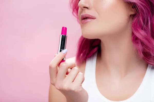 Cropped view of young woman holding lipstick isolated on pink — Stock Photo