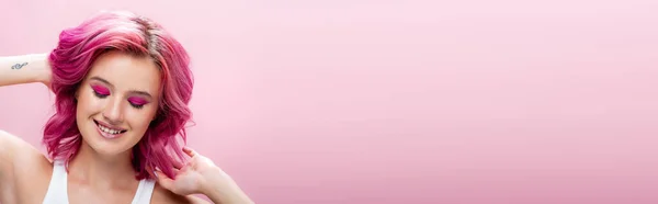 Young woman with colorful hair and makeup smiling isolated on pink, panoramic shot — Stock Photo