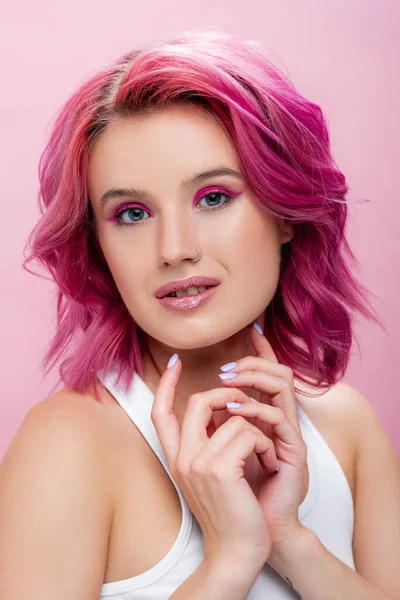 Mujer joven con el pelo colorido y maquillaje posando aislado en rosa - foto de stock