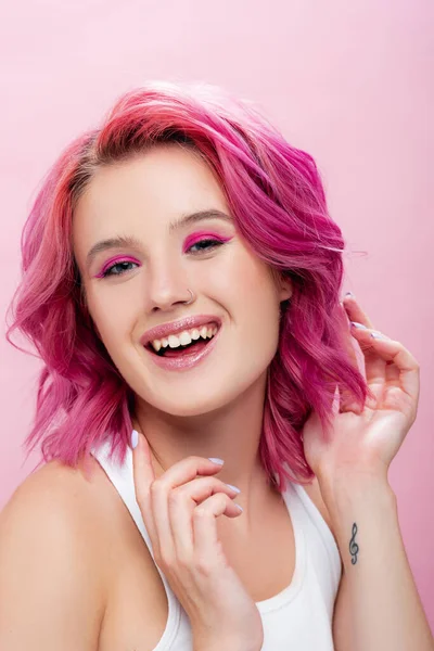 Giovane donna con capelli colorati e trucco sorridente isolato su rosa — Foto stock