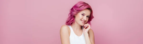 Young woman with colorful hair smiling isolated on pink, panoramic shot — Stock Photo