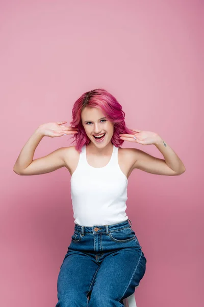 Возбужденная молодая женщина с красочными волосами жест изолирован на розовый — стоковое фото
