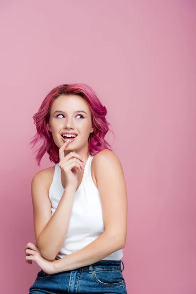 Junge Frau mit bunten Haaren schaut vereinzelt auf rosa — Stockfoto