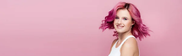 Young woman with colorful hair smiling isolated on pink, panoramic shot — Stock Photo