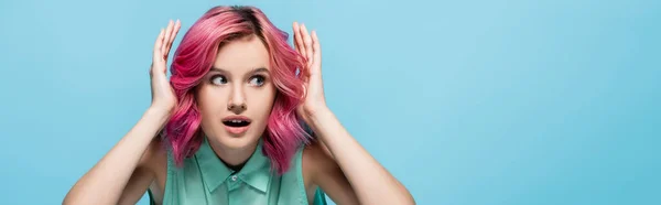 Surprised young woman with pink hair isolated on blue background, panoramic shot — Stock Photo
