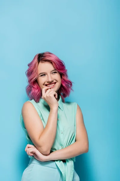 Jeune femme aux cheveux roses souriant et flirtant sur fond bleu — Photo de stock