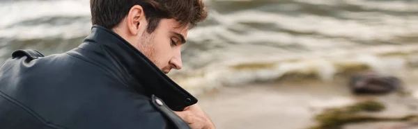 Foto panoramica dell'uomo in giacca di pelle che guarda lontano sulla riva del mare — Foto stock