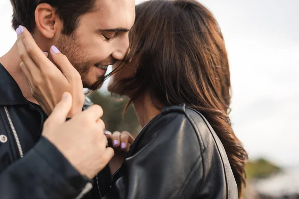 Selective focus of woman in leather jacket touching boyfriend outdoors — Stock Photo