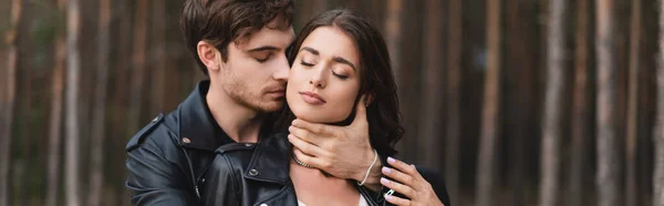 Vista panorámica del joven tocando el cuello de su novia en el bosque - foto de stock