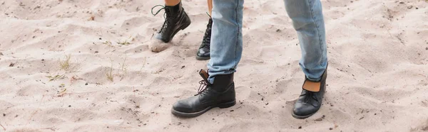 Panoramic crop of young couple walking on sandy beach — Stock Photo