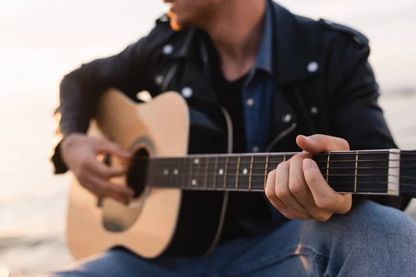 Vista ritagliata del giovane che suona la chitarra acustica all'aperto — Foto stock