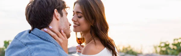 Website-Header einer Frau, die ein Glas Wein hält und ihren Freund am Strand küsst — Stockfoto