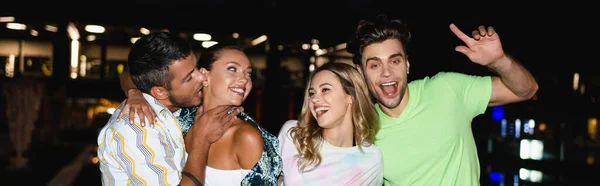 Panoramic crop of young couples embracing outdoors at night — Stock Photo