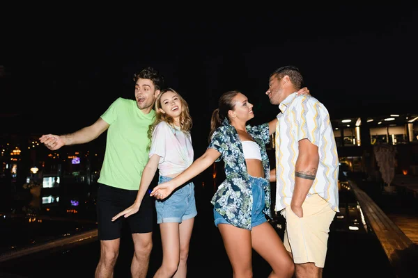 Couples excités dansant près de la piscine la nuit — Photo de stock