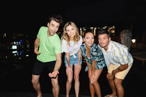 Молоді люди дивляться на камеру на відкритому повітрі вночі — стокове фото