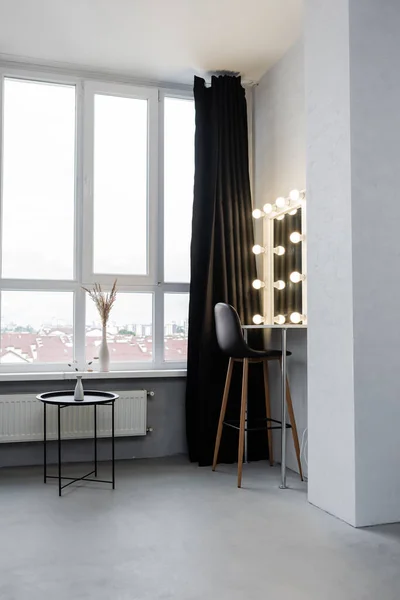 Studio interior with coffee table and mirror with light bulbs — Stock Photo