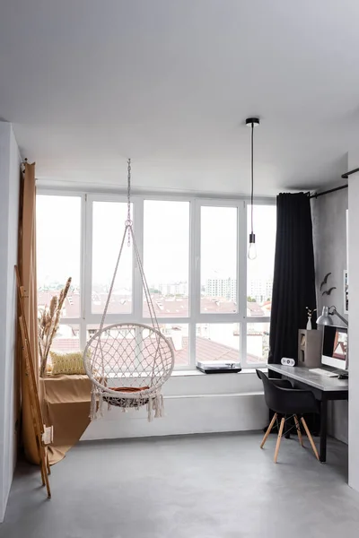 Modern studio interior with hanging chair and workplace with computer — Stock Photo