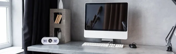 Panoramic shot of workplace with computer and decor — Stock Photo