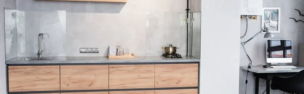 Panoramaaufnahme einer minimalistischen Küche und eines Arbeitsplatzes mit Computer — Stockfoto