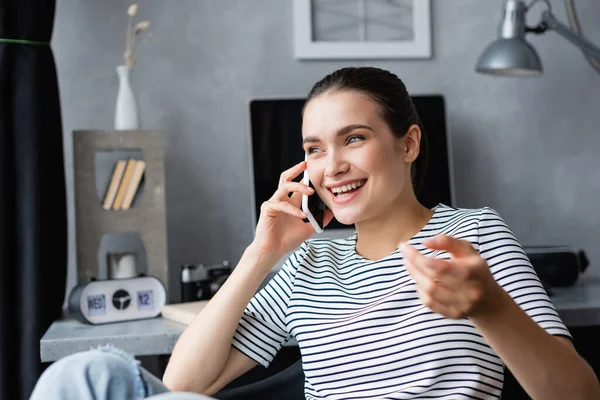 Enfoque selectivo del freelancer hablando en smartphone mientras trabaja en casa - foto de stock