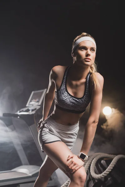 Deportiva preparándose para correr cerca de la cinta en el gimnasio - foto de stock