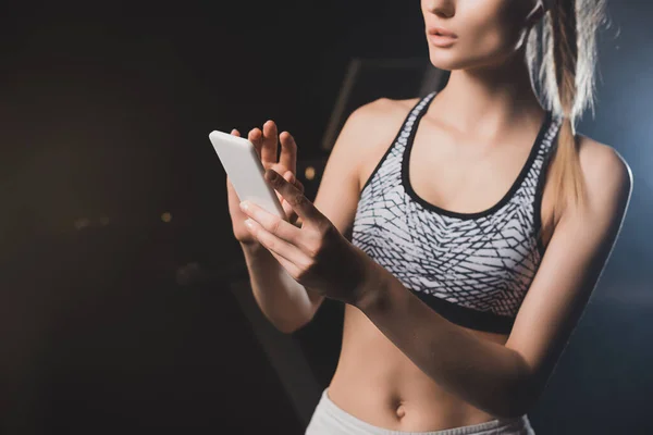 Vue recadrée de sportive à l'aide d'un téléphone portable — Photo de stock