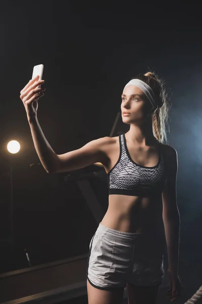 Front view of sportswoman taking selfie in gym — Stock Photo