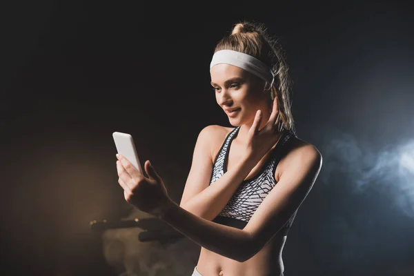 Спортсменка з мобільним телефоном приймає селфі в спортзалі — стокове фото