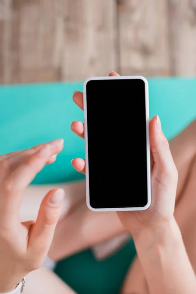 Enfoque selectivo de la mujer con teléfono celular con pantalla en blanco - foto de stock