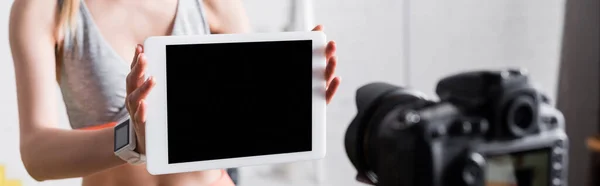 Horizontale Sportlerin zeigt digitales Tablet an Digitalkamera zu Hause — Stockfoto